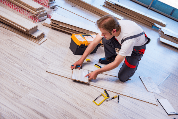 ouvrier découpant du parquet stratifié