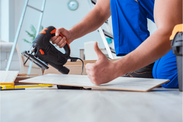 signe de pouce d'un ouvrier travaillant sur du parquet stratifié