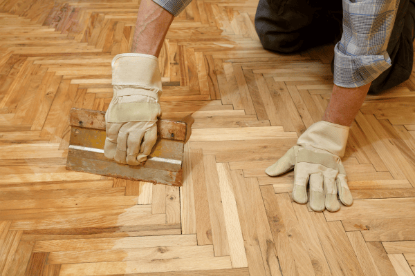 ouvrier travaillant sur un parquet ciré