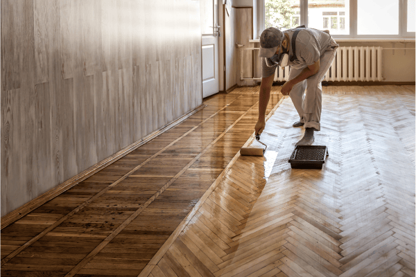 personne travaillant sur un parquet bois vitrifié